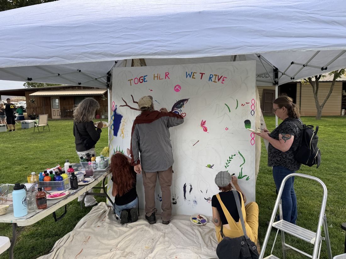 Neighbors painting the Together We Thrive canvas at Eco Fest 2026